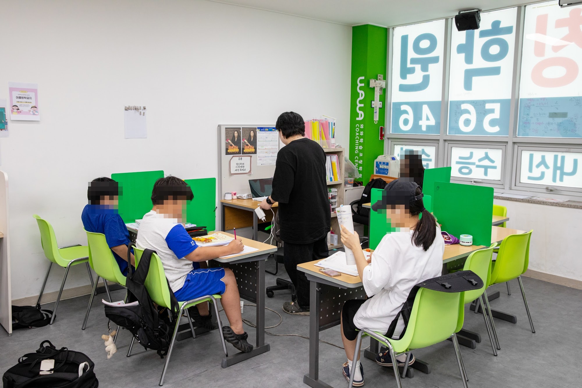 오산 금암동 와와학습코칭 세교점 교실 — 브랜드 벽 앞에서 집중하는 학생들