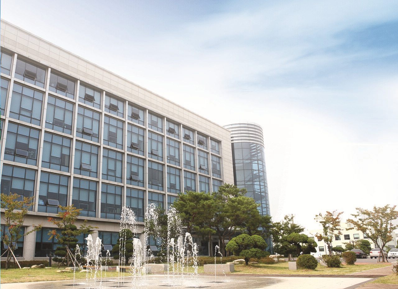한국항공대학교 본관 건물 — 넓은 잔디 광장 뒤로 좌우 대칭의 석조 본관이 서 있고, 가운데에 기둥이 늘어선 현관이 있다